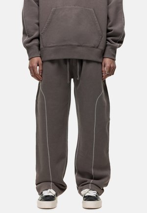 Hooded sweatshirt and sweatpants set in dark gray cotton with white stitching, featuring a front pocket and relaxed fit.