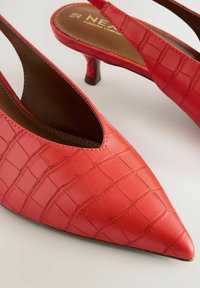 Tacchi slingback rossi in ecopelle con punta appuntita e motivo croco testurizzato; presentano un tacco basso e un interno marrone.