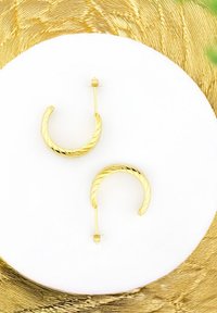 Guldspiralörhängen med en vriden design och en stiftbakstängning. Slät, glänsande yta; cirkulär form. Minimalistisk accent.