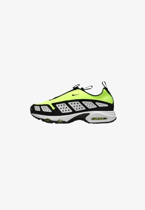 Nike sneaker featuring a neon yellow and black design, with a textured upper, prominent perforations, and visible Air cushioning in the sole.