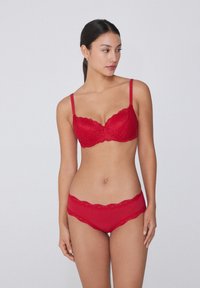 Reggiseno push-up in pizzo rosso con bordi scallopati e slip abbinati in pizzo rosso. Il tessuto sembra morbido con un delicato motivo floreale.