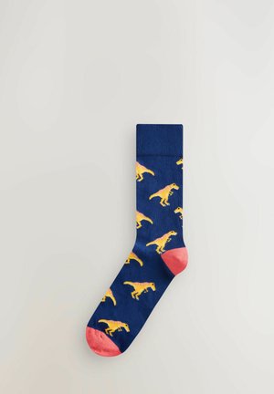 Calzini blu navy con motivo di dinosauri gialli, punta e risvolto color corallo. Realizzati in un morbido tessuto a maglia, con una parte superiore a coste.