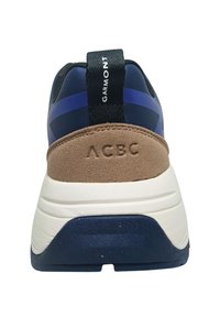 Sneaker blu navy con retro in suede marrone, suola intermedia bianca e dettagli neri. Logo "GARMONT" sul ciclo del tallone e "ACBC" impresso sul lato.