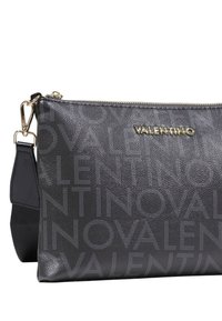 Černá kožená crossbody taška s embosovaným vzorem loga, zlatými detaily a zipem s kontrastním popruhem.