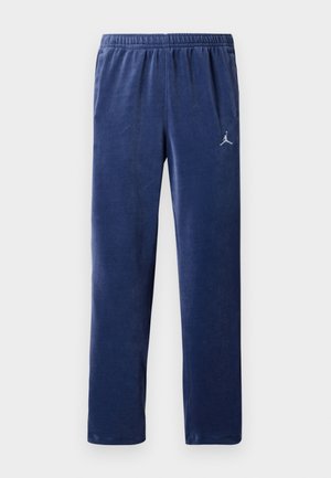 Pantalons de jogging en polaire navy avec une taille élastique, poches latérales et un logo Jordan argenté accentué sur la cuisse gauche.