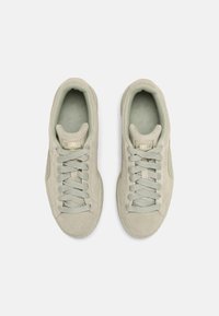 Jasnozielone zamszowe sneakersy o teksturowanym wykończeniu, zawiązywane, z wyściełanym kołnierzem i jasnozielonymi akcentami na sznurowadłach oraz wnętrzu.