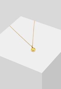 Goldene Halskette mit einem runden Anhänger, der ein strukturiertes Design und einen erhabenen Buchstaben "M" aufweist, an einer zarten Kette.