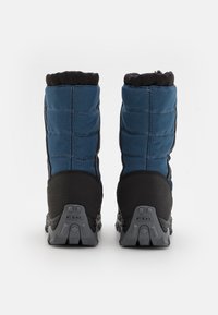 Botas impermeáveis azuis com parte superior em tecido acolchoado, solas de borracha pretas, áreas da ponta reforçadas e uma alça na parte superior para fácil calçar.