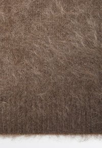 Bruine fuzzy gebreide stof met een geribbelde rand, die een zachte, harige textuur en fijn geweven patroon laat zien.