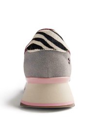 Baskets en suède gris avec un accent de talon en poil de cuir rayé noir et blanc. Semelle en caoutchouc rose et détails autour du talon pour un contraste supplémentaire.
