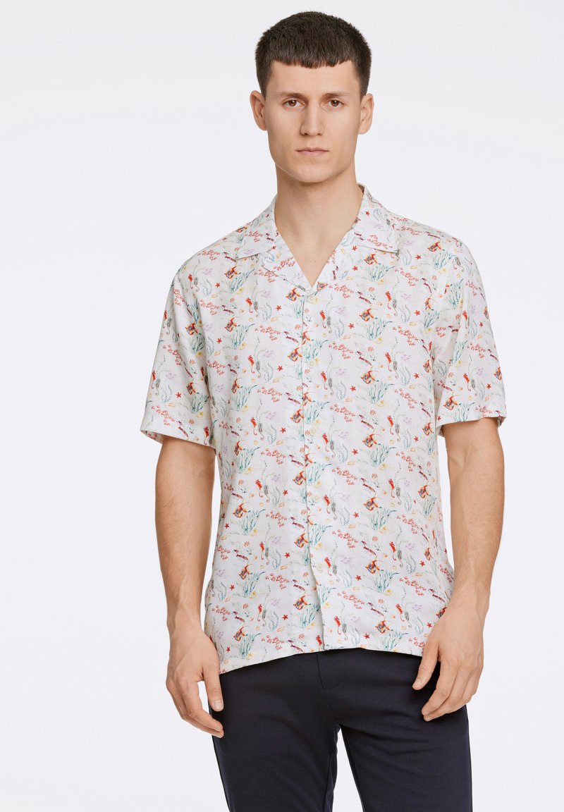 Camisa de manga corta en una tela ligera con un estampado floral de varios colores, incluyendo rojo y azul, y un cuello con muesca.