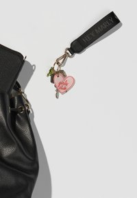 Sac à main noir texturé avec un porte-clés ornée d'un charme en forme de cœur rose portant l'inscription "club de filles" et des accents métalliques.