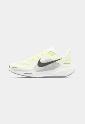 Baskets de course Nike avec une tige en mesh jaune clair et blanche, des accents gris et une semelle en caoutchouc flexible. Présentent un système de laçage.