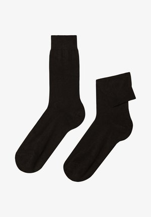 Sorte strømper lavet af et glat, elastisk materiale. De har en standard crew-længde med en forstærket tå og en udtalt ribbet skrål.