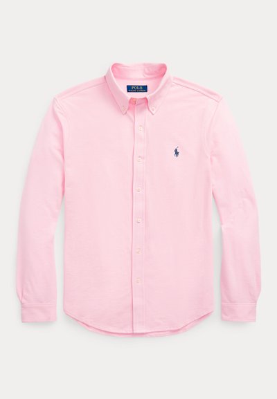 Rozā ar pogām aiztaisāma krekls ar garām piedurknēm, šauru apkakli un nelielu zilu logo kreisajā krūtīs. Kokvilnas audums ar gludu tekstūru.