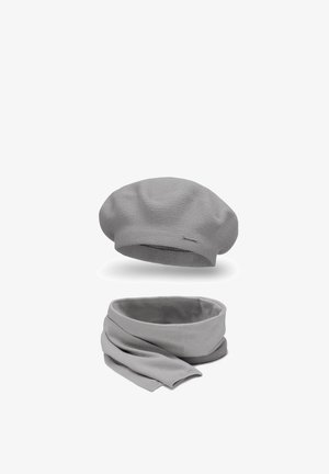 Grå strikket beret og matchende tørklæde med et tekstureret mønster og blød overflade. Tørklædet er tubulært med draperet, flydende stof.