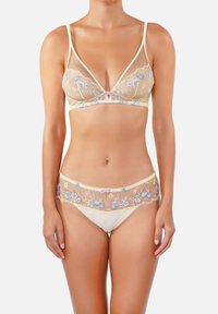 Ensemble soutien-gorge et culotte en dentelle beige clair avec broderies florales bleues et roses, présentant un tissu transparent et un petit nœud à l'avant.