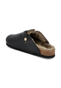 Schwarze Clogs mit einem glatten Leder-Obermaterial, Shearling-Futter, Korkfußbett und einer runden Zehenpartie. Mit einem Riemen und einem dekorativen goldenen Knopf.