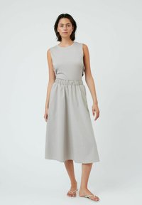 Robe sans manches gris clair avec un corsage ajusté et une taille élastique, jupe fluide arrivant au genou, texture de tissu lisse.