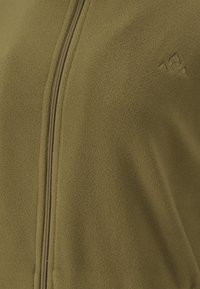 Olivgrön fleece-urkens jacka med en slät textur, som har en framdragkedja och en liten triangulär logotyp på bröstet.