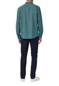 Groen geruit overhemd met lange mouwen, slim fit, en rugplooien, gecombineerd met donkere denim broek en witte sneakers.