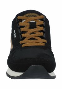 Black and tan athletic shoe featuring lace-up design, suede and fabric materials, rubber sole, and textured accents.