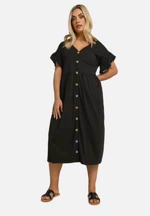 Vestido negro de botones en el frente con mangas cortas acampanadas, escote en V y cintura fruncida. Presenta botones redondos y un dobladillo a la altura de la rodilla.