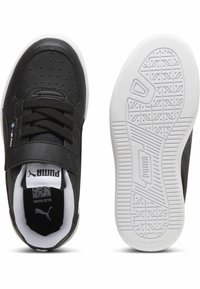 Zapatilla negra con parte superior de cuero sintético, cierre de cordones y correa de velcro. Suela de goma blanca con patrón de agarre texturizado. El interior cuenta con un collar acolchado.