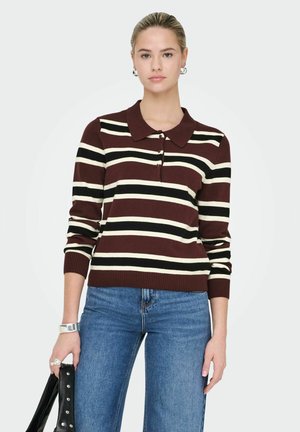 Bordeauxrode en crème gestreepte gebreide trui met een kraag en een drukknoopsluiting met drie knopen, met ribgebreide manchetten en onderrand. Gepaard met blauwe spijkerbroeken.