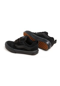 Sneakers neri in materiali scamosciati e sintetici, con suola in gomma nera testurizzata e motivo della suola in gomma. Inclusi lacci e bandierina sul tallone.