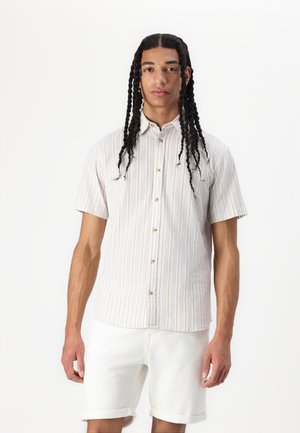 Kortermet skjorte med knapper i lett stoff med vertikale striper i beige og hvitt, med spiss krage og rund nederkant.