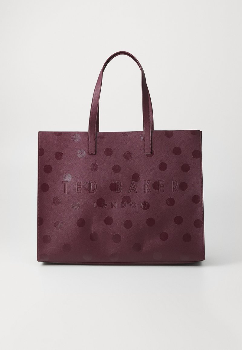 Bordeaux kleurige tote bag met een patroon, voorzien van grote tonale stippen en de gegraveerde tekst "TED BAKER LONDON" aan de voorkant. Duurzaam materiaal en dubbele handvatten.