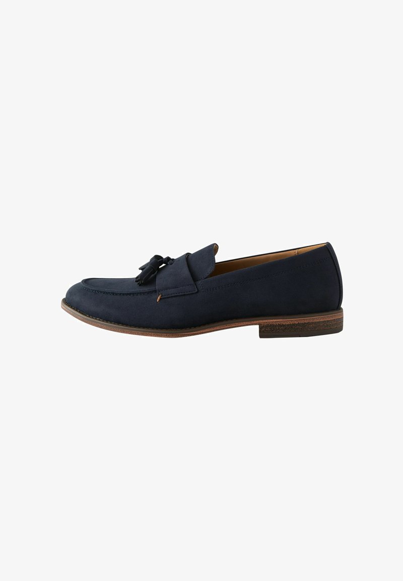 Navy-Suede-Slipper mit runder Zehenform, dekorativen Quasten und einer kontrastierenden braunen Sohle. Glatte Textur und minimale Nähdetails.
