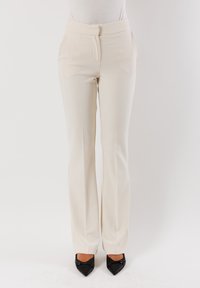 Pantaloni su misura color crema in tessuto liscio, design a gamba dritta e piega anteriore discreta. Presentano una chiusura con zip e gancio discreti.