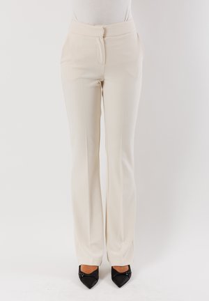 Pantaloni su misura color crema in tessuto liscio, design a gamba dritta e piega anteriore discreta. Presentano una chiusura con zip e gancio discreti.