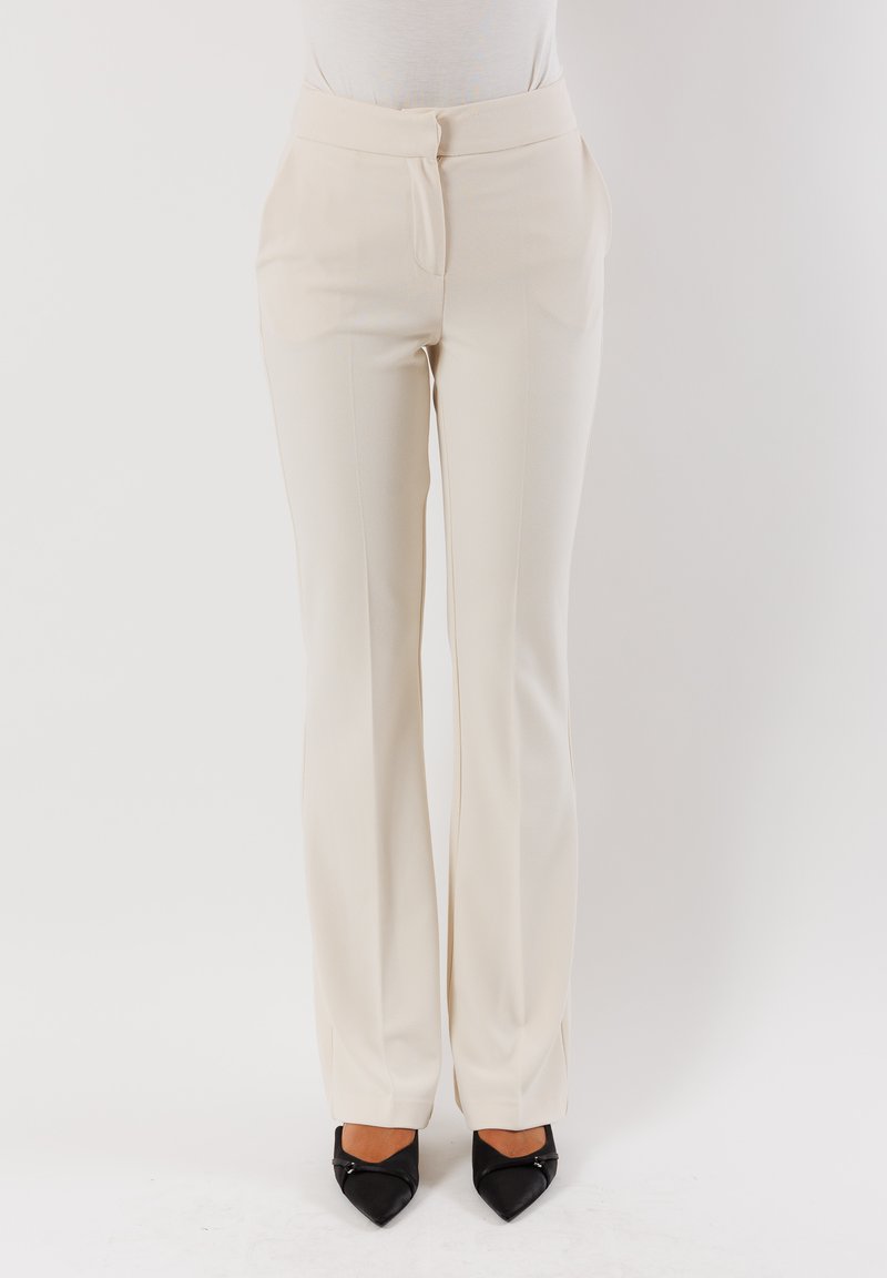 Pantaloni su misura color crema in tessuto liscio, design a gamba dritta e piega anteriore discreta. Presentano una chiusura con zip e gancio discreti.