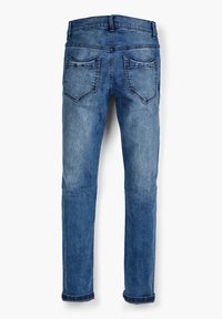 Modré deniminové džínsy s rovnými nohavicami, sú vybavené dvomi zadnými vreckami, s miernym vyblednutím a srolovanými lemami pri členkoch.