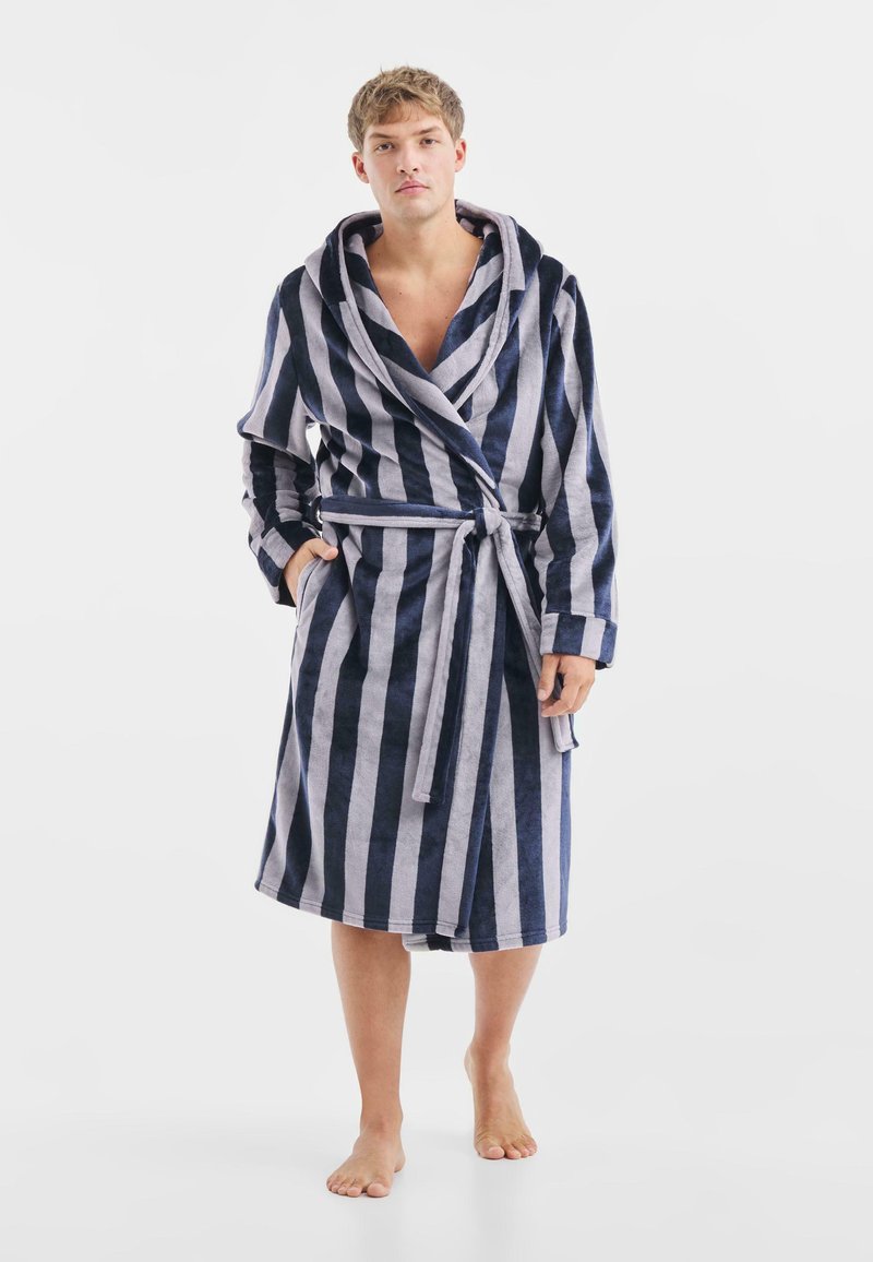 Accappatoio a righe in blu navy e grigio chiaro, con colletto a scialle, tasche e cintura da annodare. Tessuto morbido e texture.