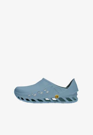 Scarpa slip-on azzurro chiaro con suola e tomaia ventilate, cinturino posteriore rialzato e piccolo logo giallo sul lato.