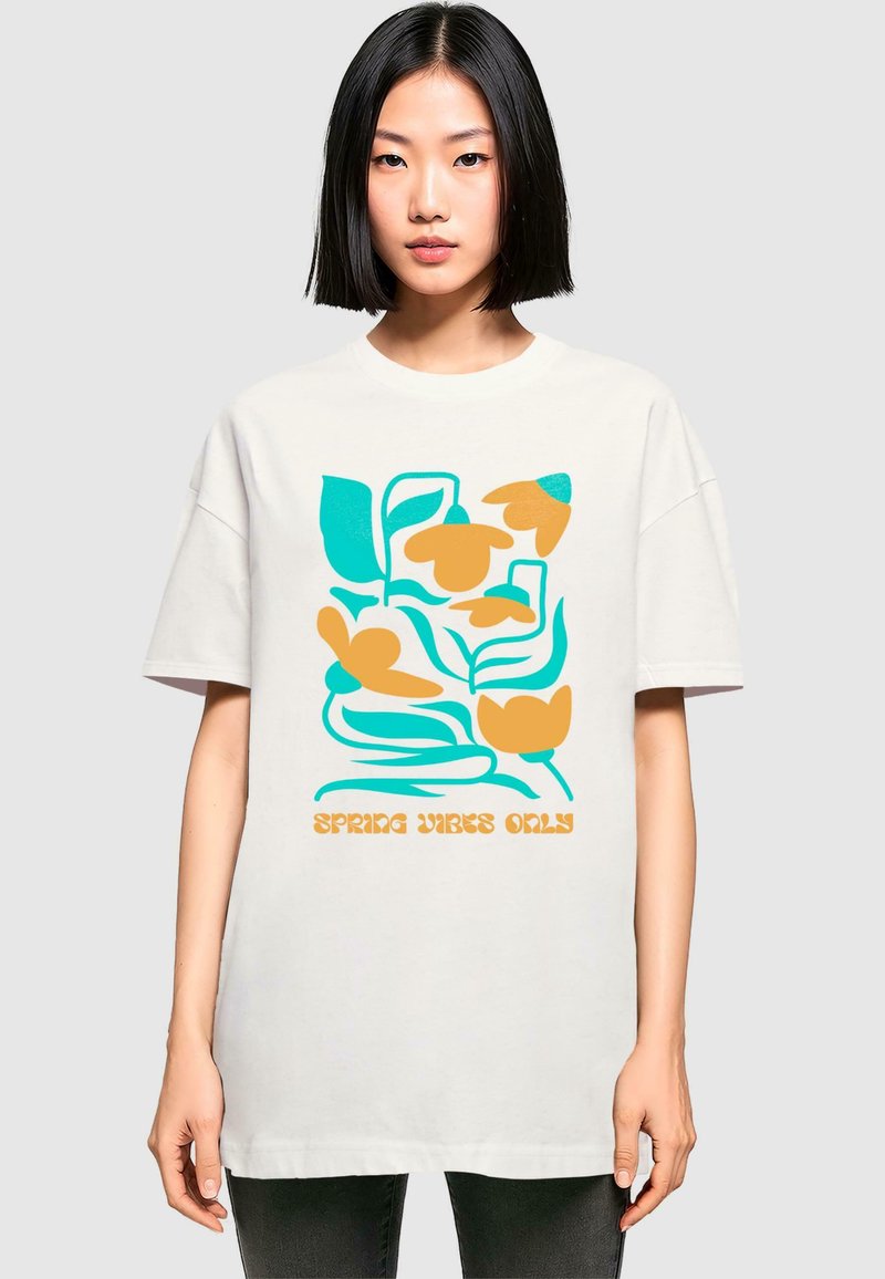 Hvid oversized T-shirt med en floral illustration i teal og orange, med teksten "SPRING VIBES ONLY" nederst.