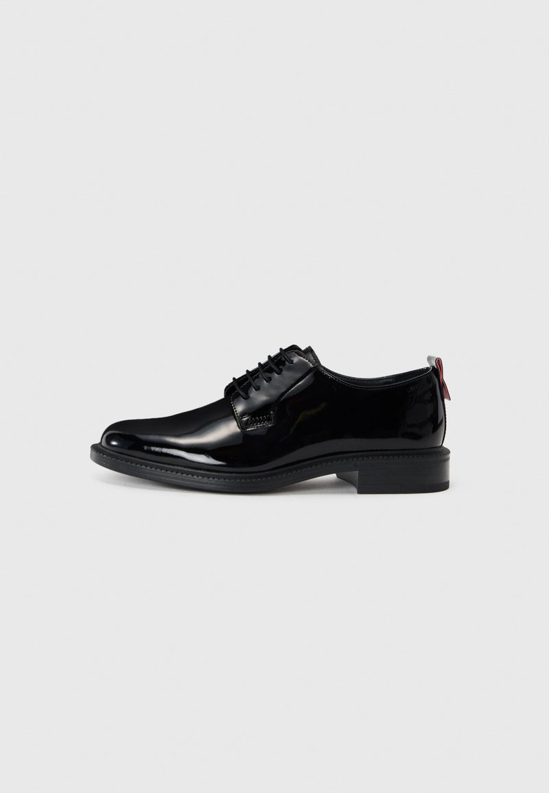 Chaussures en cuir verni noir avec une texture lisse, à lacets, à bout rond et avec un petit talon empilé bas comportant un accent rouge à l'arrière.
