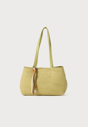 Bolsa de tela verde con dos asas largas, forma redondeada y detalle decorativo de cinta multicolor en el lateral.