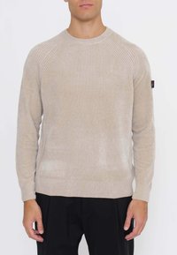 Beiger Strickpullover mit gerippten Details an den Schultern, rundem Ausschnitt und langen Ärmeln. Weiche Textur, tailliert, dezenter Glanz.