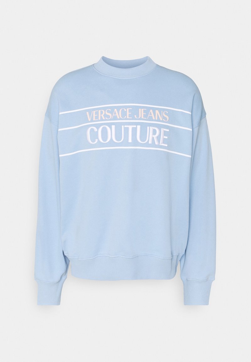 Ljusblå sweatshirt i bomull, med ribbad mudd och nacke. Broderad text "VERSACE JEANS COUTURE" i vitt och rosa.