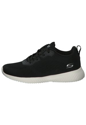 Scarpa sportiva nera con parte superiore texturizzata, dotata di dettagli a righe, design con lacci e suola in gomma bianca e flessibile. Accent sur logo argentato sul lato.