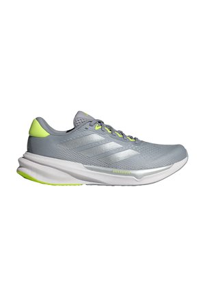 Hellgrauer Sportschuh mit Mesh-Obermaterial, silbernen Akzenten, gelb-grünem Fersendetail und weißer Zwischensohle. Entwickelt für Komfort und Leistung.