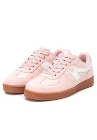Zapatillas de ante de color rosa claro con un acento sintético blanco. Punta redondeada, diseño con cordones y suela de goma marrón con un agarre texturizado.