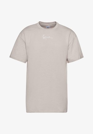 Vaaleanbeige puuvillapaita, jossa on pyöreä kaula-aukko, lyhyet hihat ja valkoinen käsinkirjoitettu logo edessä. Liukas pinta ja standardi istuvuus.