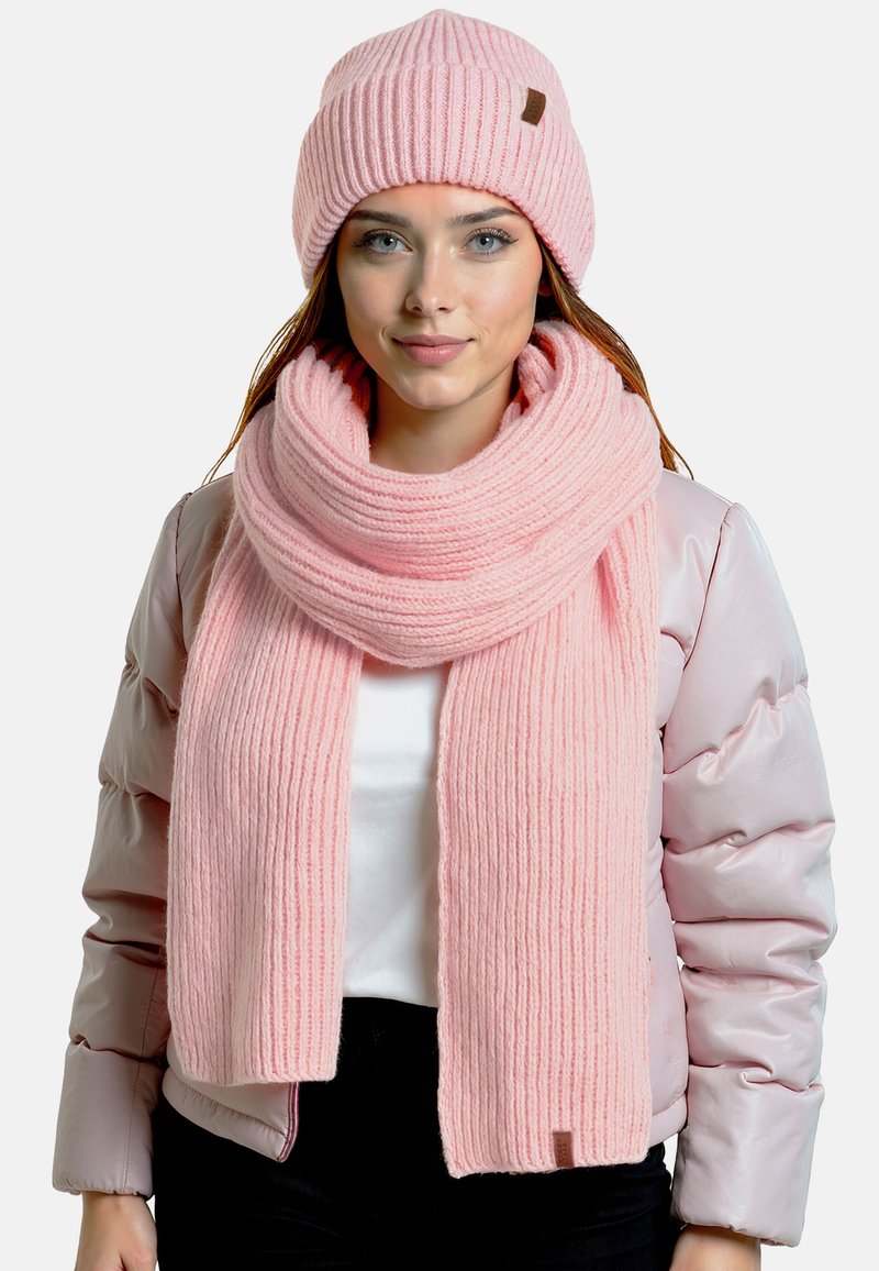 Conjunto de bufanda y gorro de punto acanalado en color rosa, hecho de hilo suave, con un acabado texturizado y un pequeño acento de cuero marrón en el gorro.