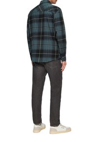 Koszula w kratę w odcieniach niebieskiego, czarnego i białego, zestawiona z ciemnymi dżinsami i jasnymi sneakersami. Posiada długie rękawy oraz kołnierzyk zapinany na guziki.